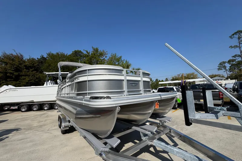 Slide: The Image of 2026 Bennington 22 LFB pontoon boat on trailer, parked outdoors under clear blue sky. - 6