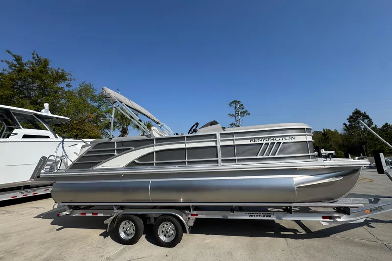 Slide: The Image of 2026 Bennington 22 LFB pontoon boat on trailer under clear blue sky. - 8