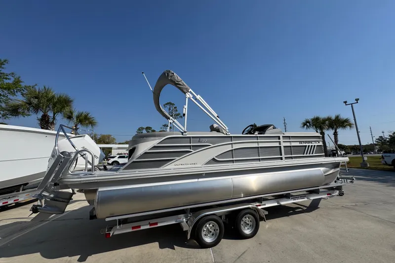 Slide: The Image of 2026 Bennington 22 LFB pontoon boat on trailer under clear blue sky. - 9