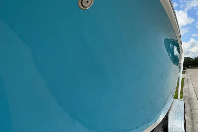 Slide: The Image of 2024 Key West 263 FS boat hull in vibrant blue, parked on a trailer. - 22