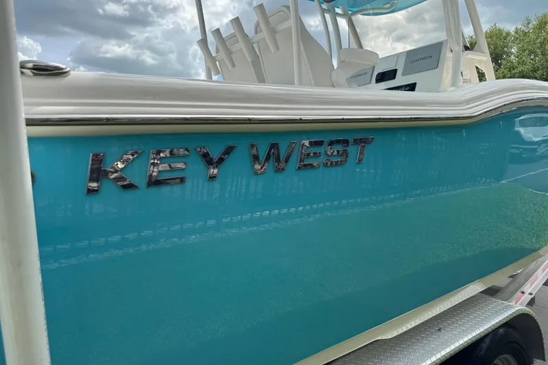 Slide: The Image of 2024 Key West 263 FS boat with turquoise hull and chrome lettering. - 26