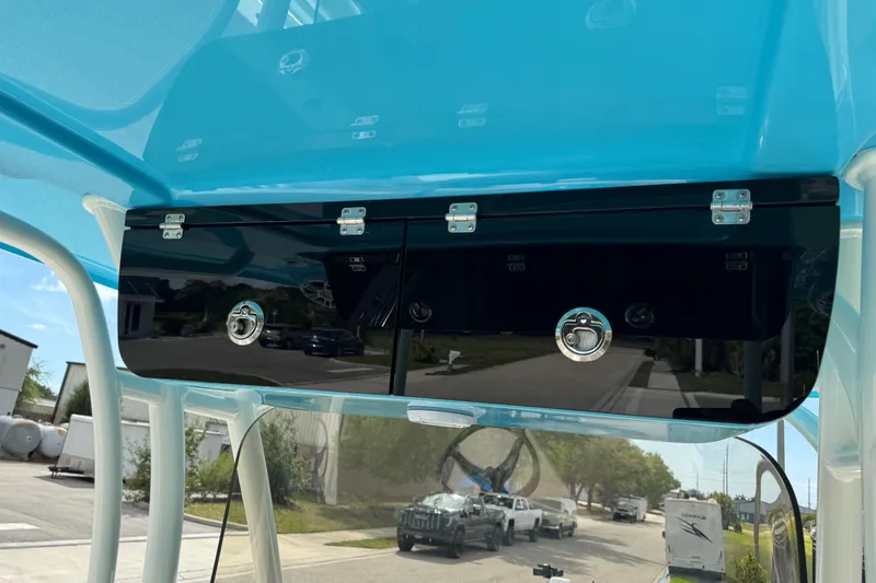 Slide: The Image of 2024 Key West 263 FS boat storage compartment with blue canopy and secure latches. - 32