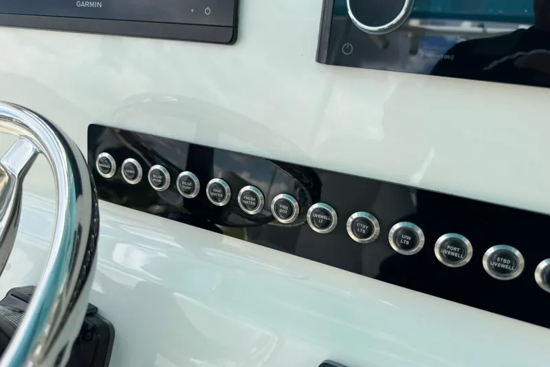 Slide: The Image of Control panel of 2024 Key West 263 FS boat with labeled buttons and steering wheel. - 40