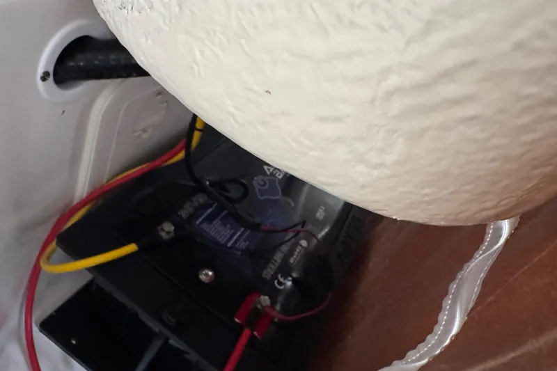 Slide: The Image of Battery compartment of 2024 Key West 263 FS boat with connected cables. - 49