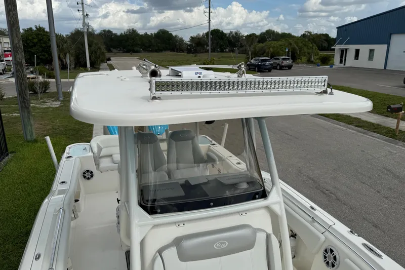 Slide: The Image of 2024 Key West 263 FS boat with T-top and seating, parked on a street. - 63