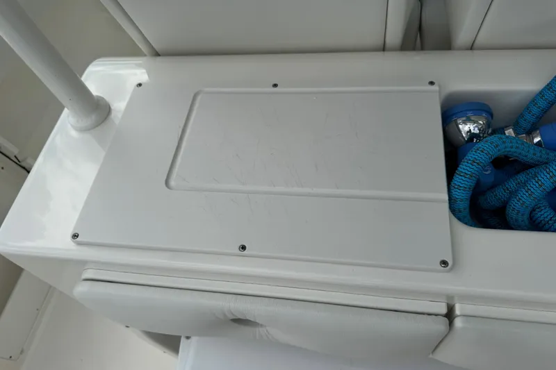 Slide: The Image of 2024 Key West 263 FS boat storage compartment with blue rope and white panel. - 81