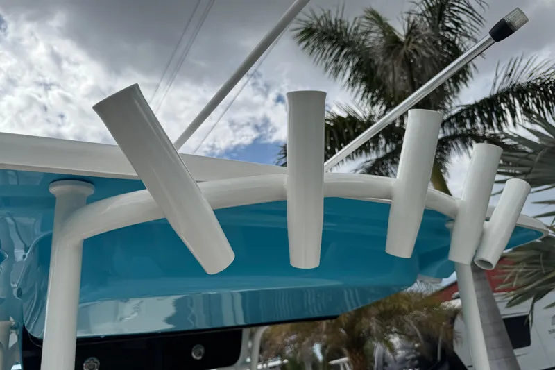 Slide: The Image of 2024 Key West 263 FS boat rod holders against a cloudy sky and palm trees. - 85