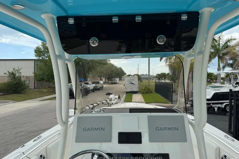 Slide: The Image of 2024 Key West 263 FS boat dashboard with Garmin navigation system, blue canopy, and outdoor setting. - 92