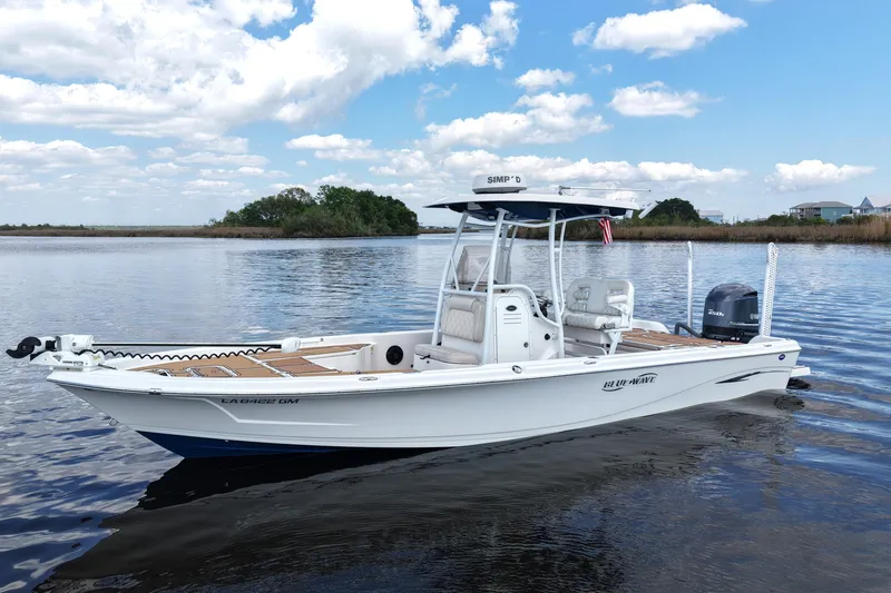 Slide: The Image of 2021 Blue Wave 2600 PureBay boat on calm water under a blue sky. - 10