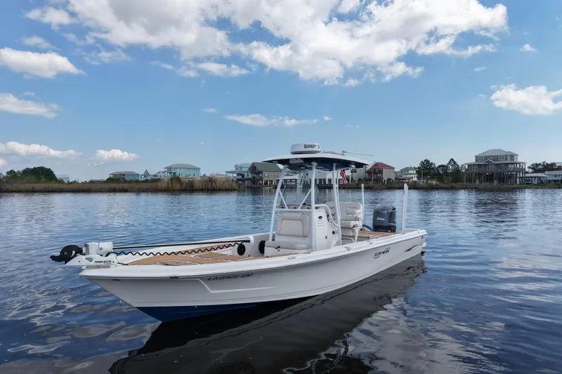 Slide: The Image of 2021 Blue Wave 2600 PureBay boat on calm water under a blue sky. - 13