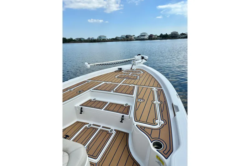 Slide: The Image of 2021 Blue Wave 2600 PureBay boat on calm water, featuring sleek deck design. - 14