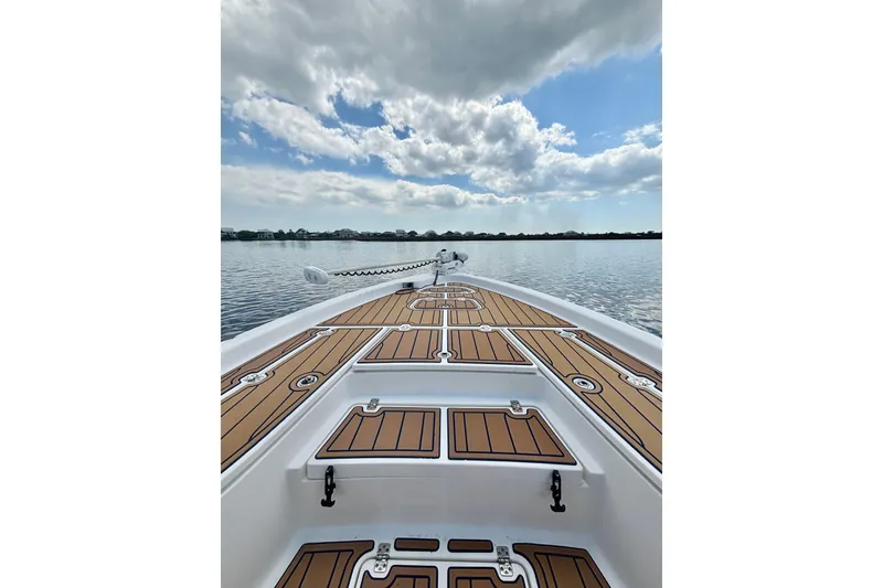 Slide: The Image of 2021 Blue Wave 2600 PureBay boat on calm water under a partly cloudy sky. - 16