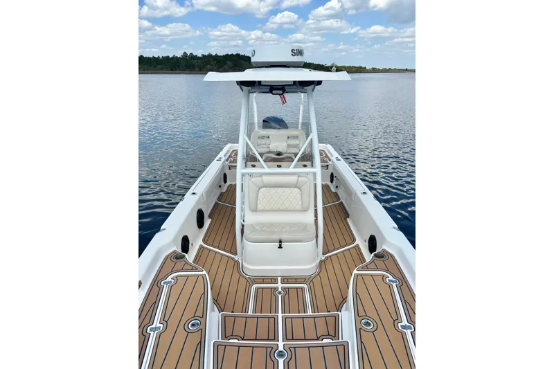 Slide: The Image of 2021 Blue Wave 2600 PureBay boat on calm water, featuring sleek deck design. - 18
