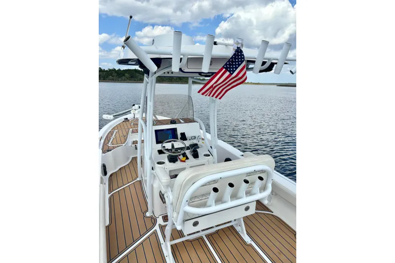 Slide: The Image of 2021 Blue Wave 2600 PureBay boat with American flag on calm water. - 24