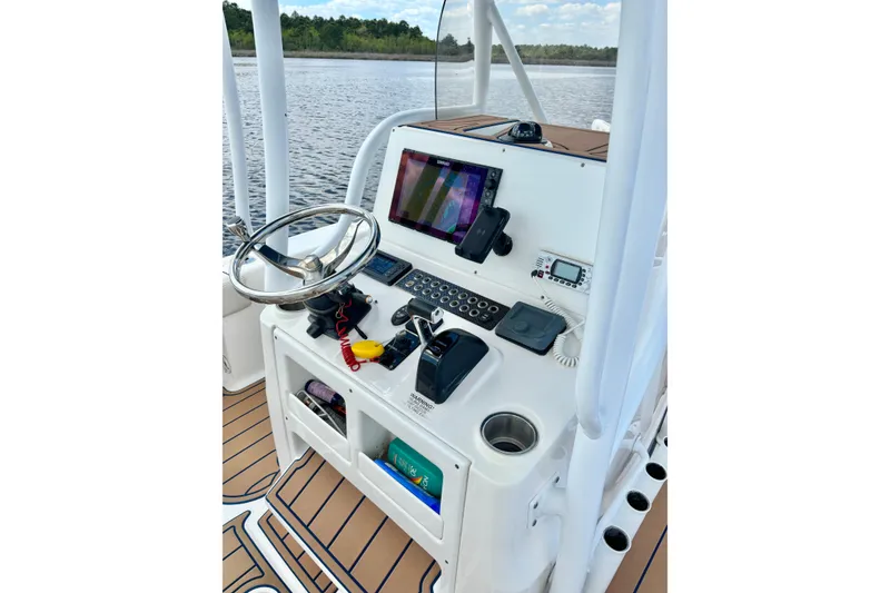 Slide: The Image of 2021 Blue Wave 2600 PureBay boat console with steering wheel and navigation equipment. - 25