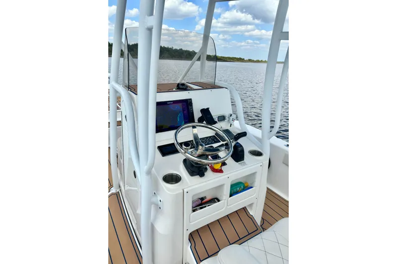 Slide: The Image of 2021 Blue Wave 2600 PureBay boat console with steering wheel and navigation system. - 27