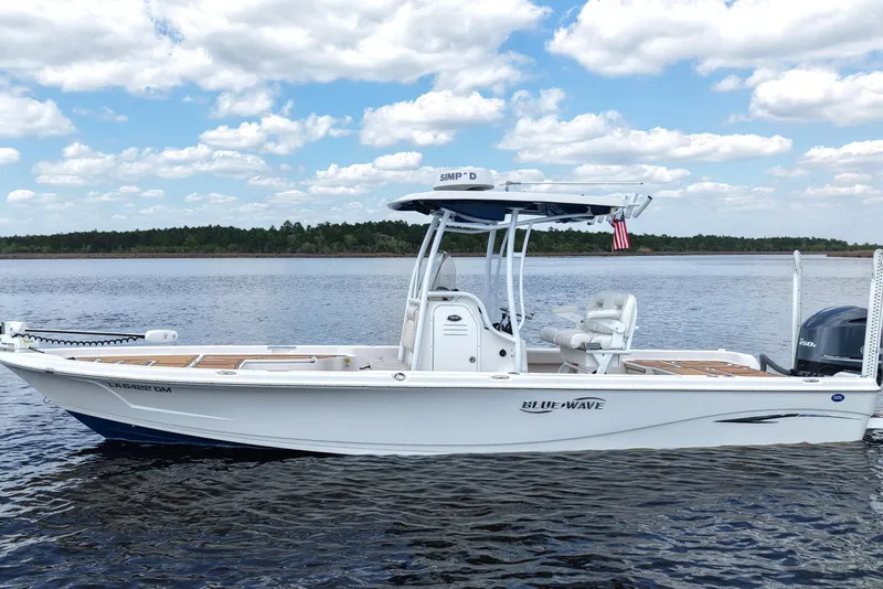 Slide: The Image of 2021 Blue Wave 2600 PureBay boat on calm water under a partly cloudy sky. - 4