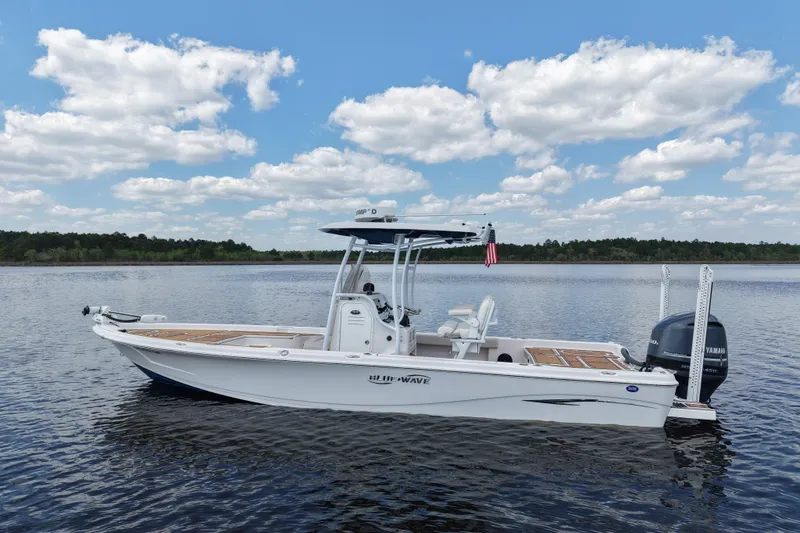 Slide: The Image of 2021 Blue Wave 2600 PureBay boat on calm water under a partly cloudy sky. - 6