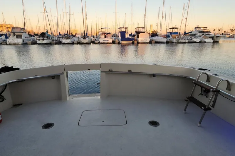 Slide: The Image of 1978 Hatteras 45 Express Sportfish boat deck with marina view at sunset. - 13