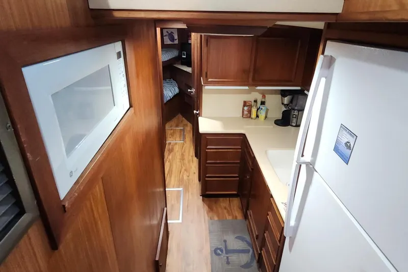 Slide: The Image of 1978 Hatteras 45 Express Sportfish interior kitchen with wood cabinets and modern appliances. - 14