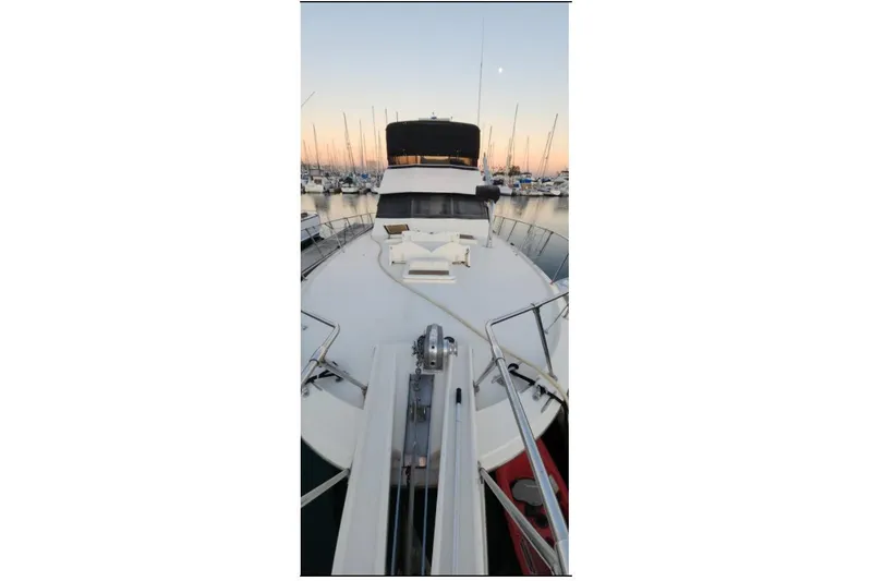 Slide: The Image of 1978 Hatteras 45 Express Sportfish yacht docked at sunset, showcasing spacious deck. - 17