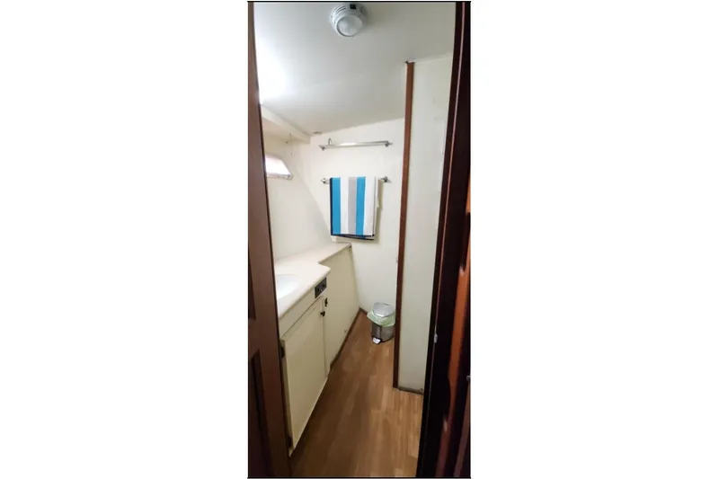 Slide: The Image of 1978 Hatteras 45 Express Sportfish bathroom with wood flooring and white cabinetry. - 21