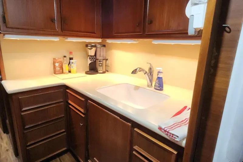 Slide: The Image of 1978 Hatteras 45 Express Sportfish kitchen with wooden cabinets and modern sink. - 3