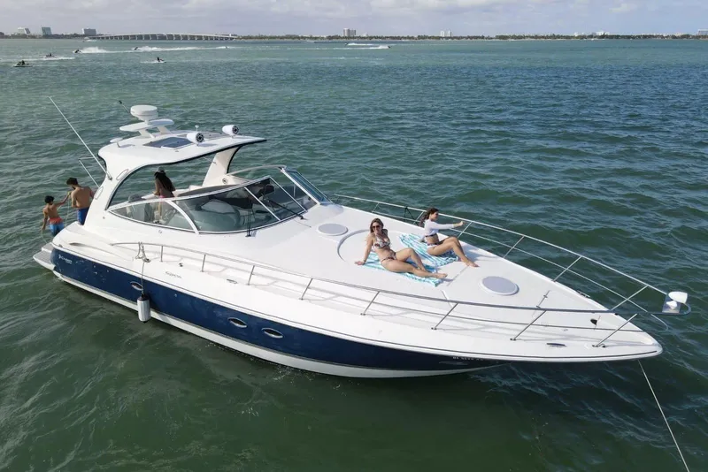 The Image of 2005 Cruisers Yachts 440 Express on water with people relaxing on deck. - 0