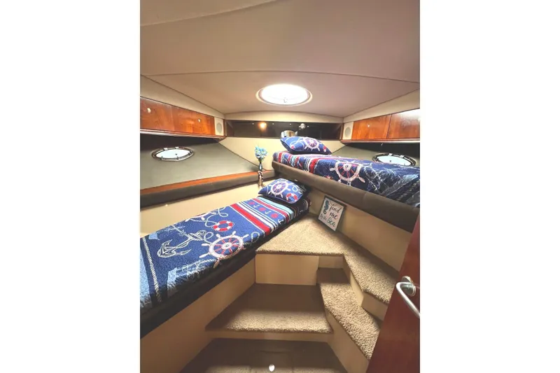 Slide: The Image of Interior cabin of 2005 Cruisers Yachts 440 Express with nautical-themed bedding. - 14