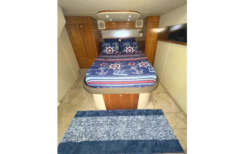 Slide: The Image of Cozy cabin interior of 2005 Cruisers Yachts 440 Express with nautical-themed bedding. - 15