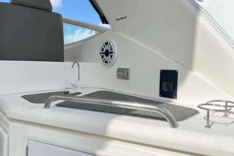 Slide: The Image of 2005 Cruisers Yachts 440 Express cockpit with sink and speaker, showcasing luxury features. - 19
