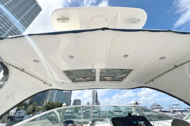 Slide: The Image of 2005 Cruisers Yachts 440 Express cockpit view with city skyline and blue sky. - 22