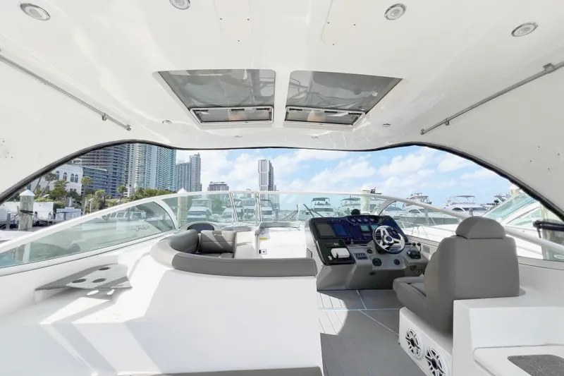 Slide: The Image of 2005 Cruisers Yachts 440 Express cockpit with modern helm and seating, city skyline view. - 23