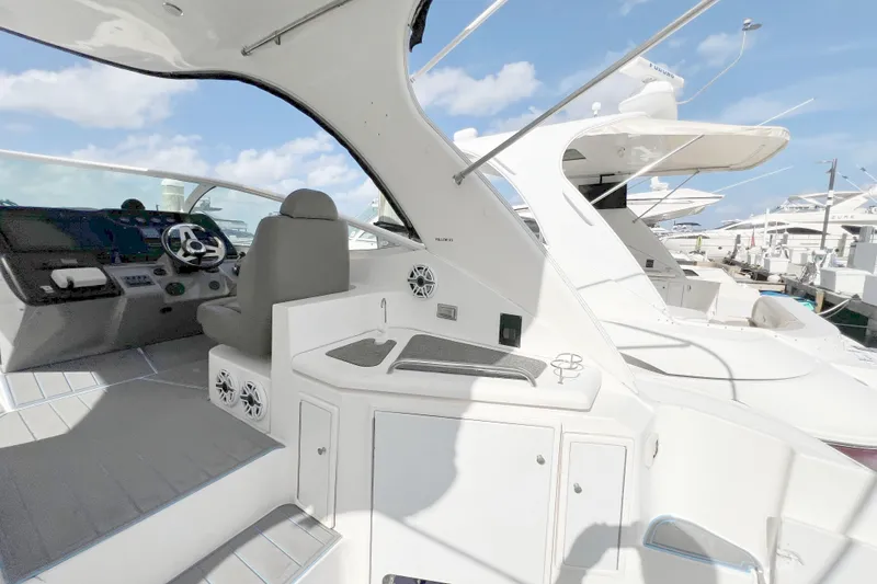 Slide: The Image of 2005 Cruisers Yachts 440 Express cockpit with helm, seating, and marina view. - 25