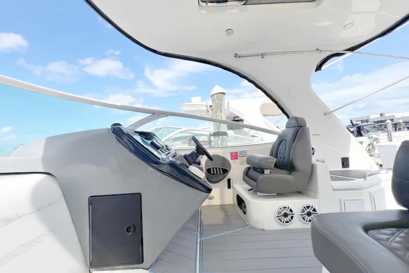 Slide: The Image of 2005 Cruisers Yachts 440 Express helm with leather seating and modern controls. - 30