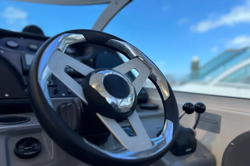 Slide: The Image of Steering wheel of 2005 Cruisers Yachts 440 Express against a clear blue sky. - 34