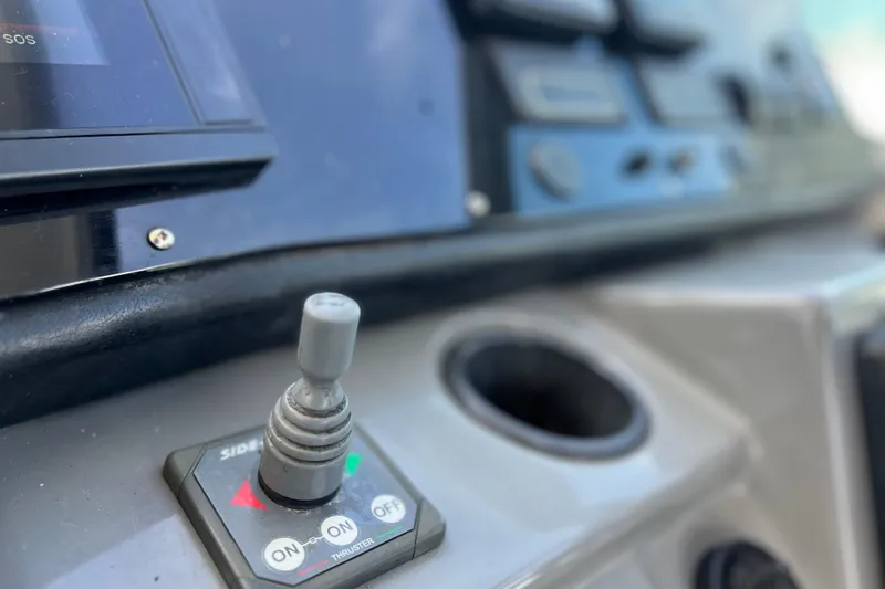 Slide: The Image of Control panel of a 2005 Cruisers Yachts 440 Express, featuring a joystick and thruster controls. - 36