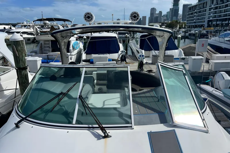 Slide: The Image of 2005 Cruisers Yachts 440 Express docked at marina with city skyline backdrop. - 38
