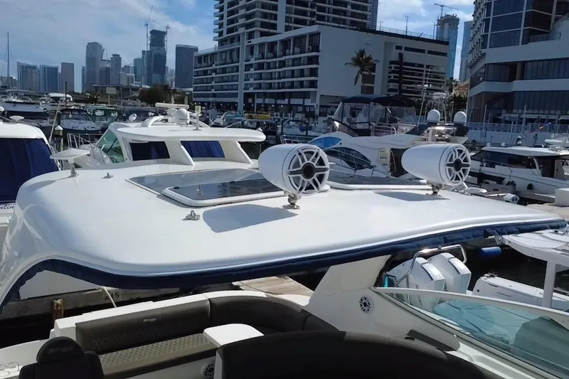 Slide: The Image of 2005 Cruisers Yachts 440 Express docked in a marina with city skyline backdrop. - 39