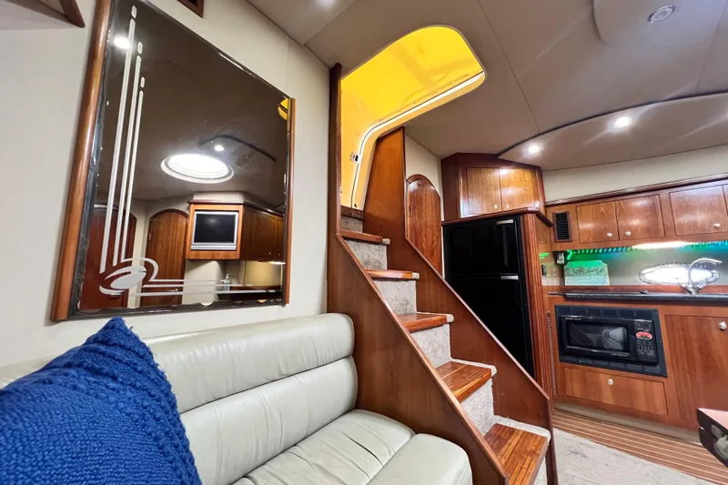 Slide: The Image of Interior of 2005 Cruisers Yachts 440 Express with wooden cabinetry and cozy seating area. - 48