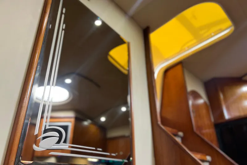 Slide: The Image of Interior of 2005 Cruisers Yachts 440 Express, featuring elegant wood finishes and modern lighting. - 49