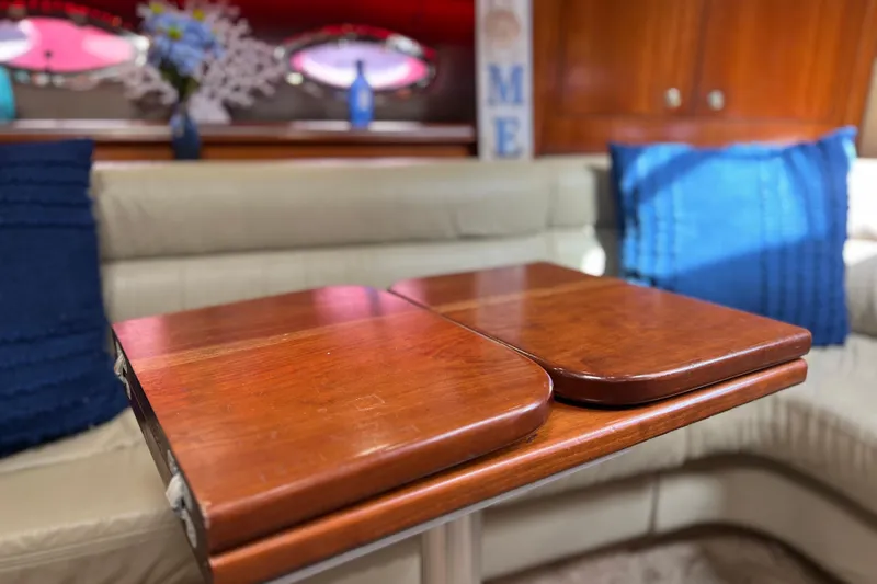 Slide: The Image of Interior of 2005 Cruisers Yachts 440 Express with wooden table and blue accents. - 50