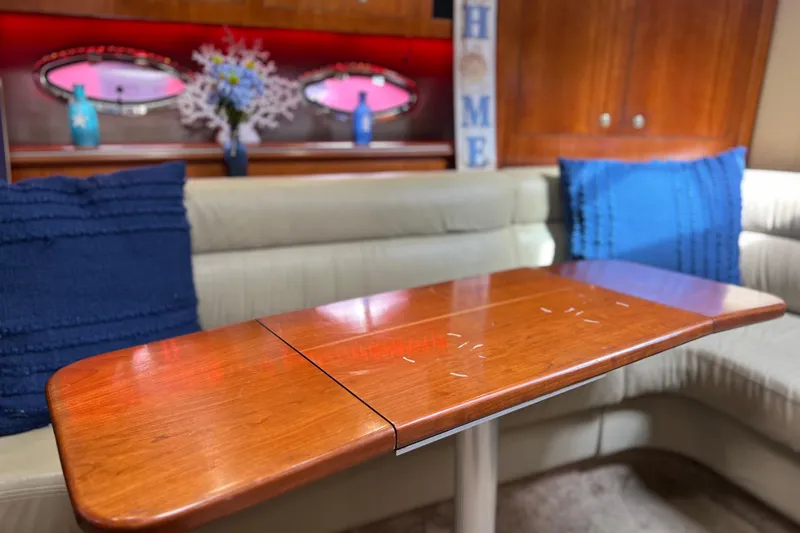 Slide: The Image of Interior of 2005 Cruisers Yachts 440 Express with wooden table and blue cushions. - 51