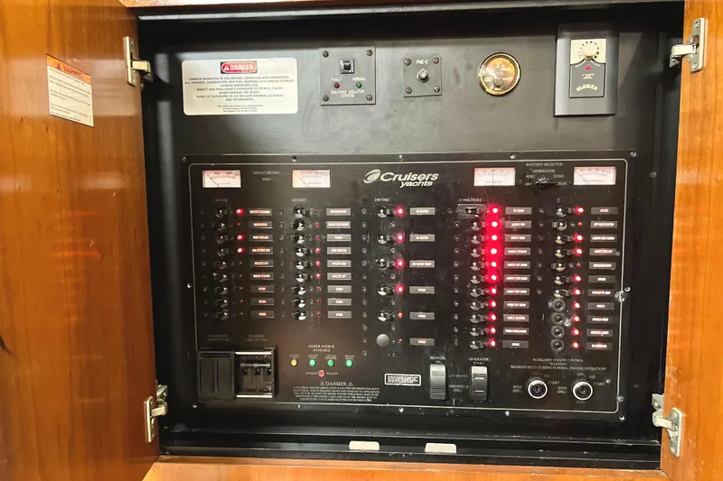 Slide: The Image of Electrical panel of a 2005 Cruisers Yachts 440 Express, featuring various switches and indicators. - 53