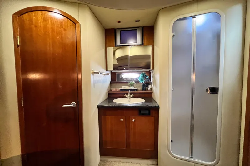 Slide: The Image of Luxurious bathroom interior of 2005 Cruisers Yachts 440 Express with wooden cabinetry and shower. - 63