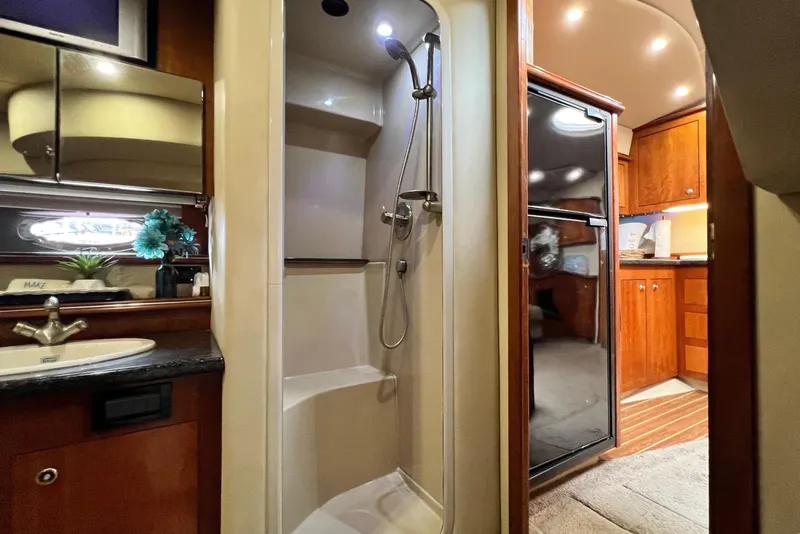 Slide: The Image of Interior of 2005 Cruisers Yachts 440 Express, featuring a shower, sink, and wooden cabinetry. - 66