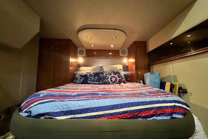 Slide: The Image of Luxurious cabin interior of 2005 Cruisers Yachts 440 Express with nautical-themed bedding. - 71