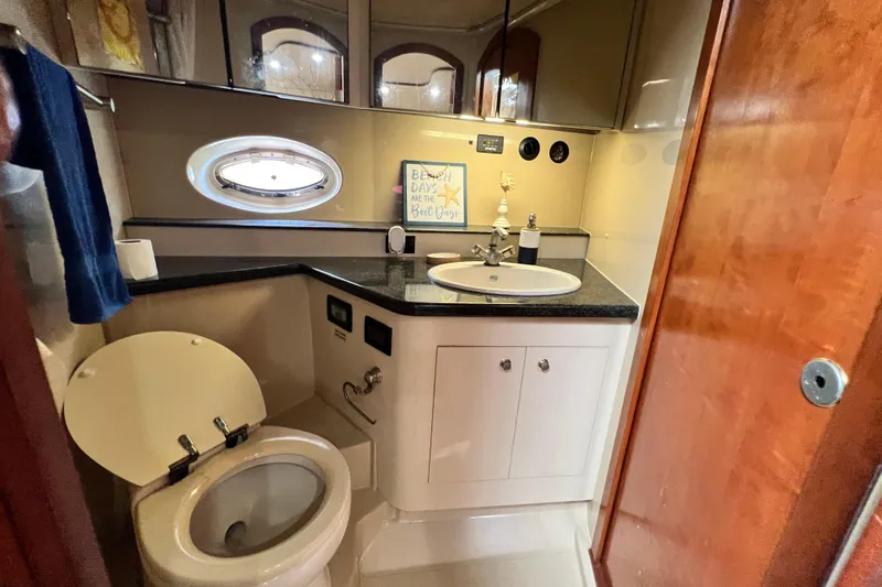 Slide: The Image of Luxurious bathroom in 2005 Cruisers Yachts 440 Express with modern fixtures and porthole window. - 73