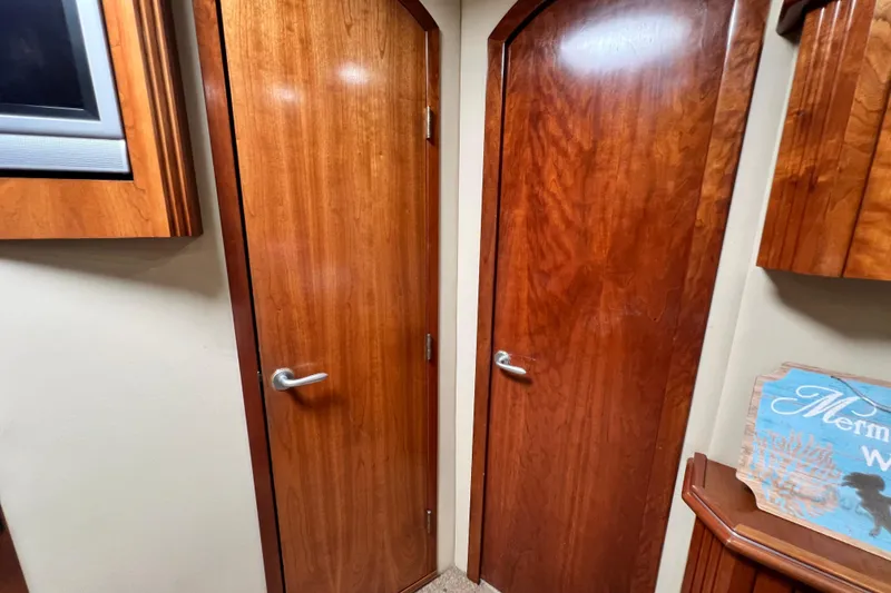 Slide: The Image of Interior of 2005 Cruisers Yachts 440 Express with wooden doors and nautical decor. - 74