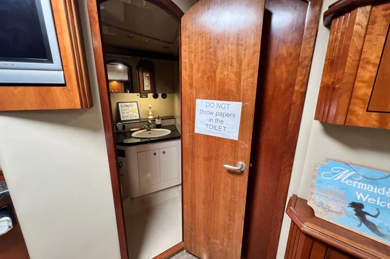 Slide: The Image of Interior of 2005 Cruisers Yachts 440 Express bathroom with wooden door and sign. - 75